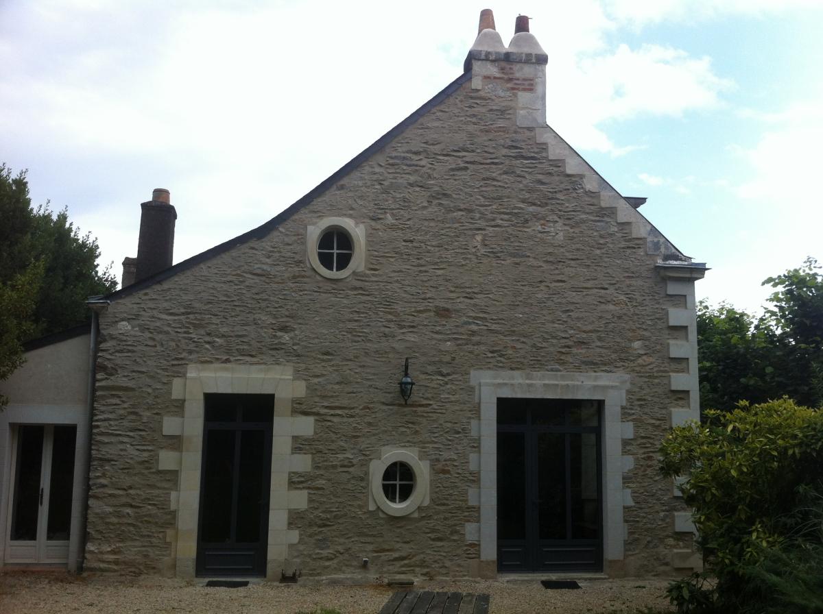 Réfection d'un pignon avec oeil de boeuf en pierre, tuffeau et joints a la chaux